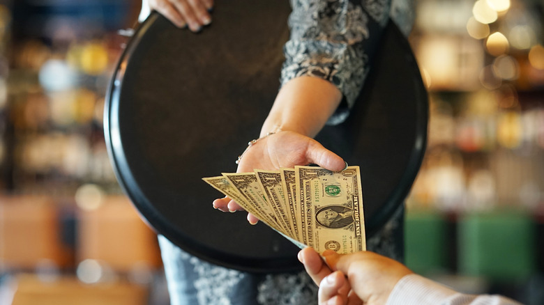 A server taking cash tips