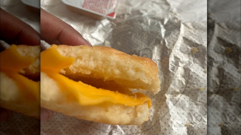 Person holding a Chick-fil-A chicken biscuit missing chicken