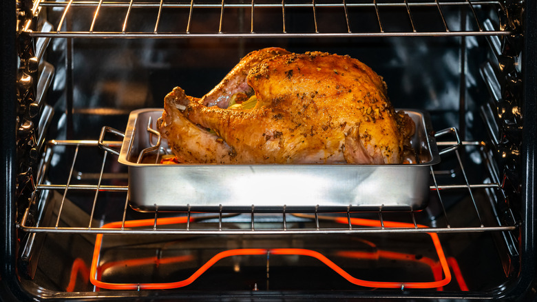 whole turkey in the oven on a roasting pan