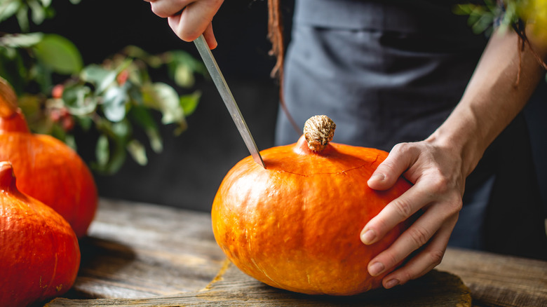 Person slicing a pumpkin