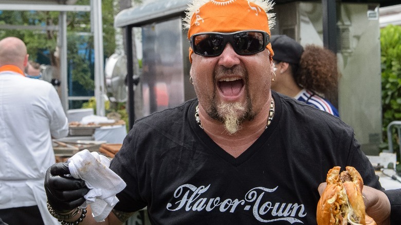 Guy Fieri holding sandwich 