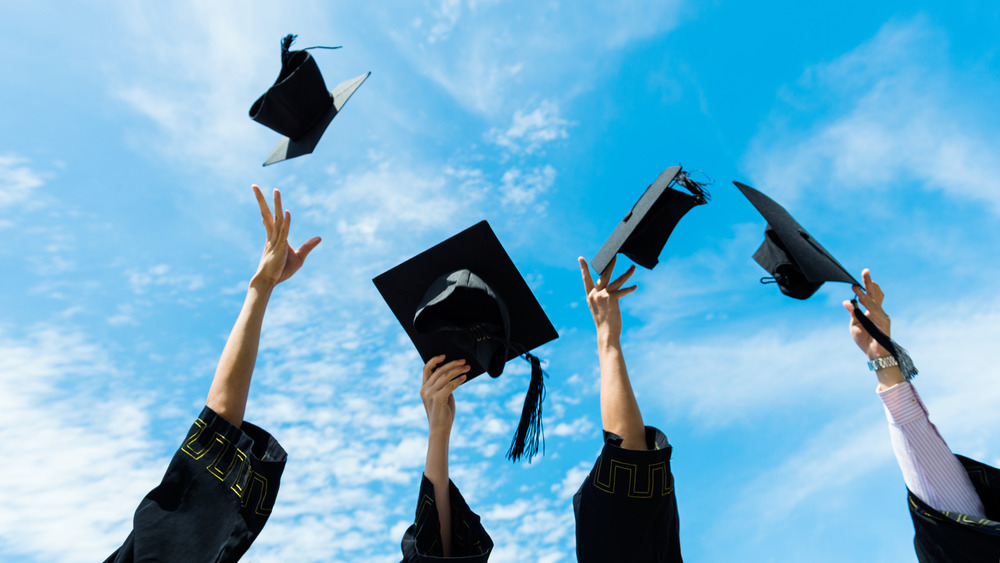 Graduation caps tossed into blue sky