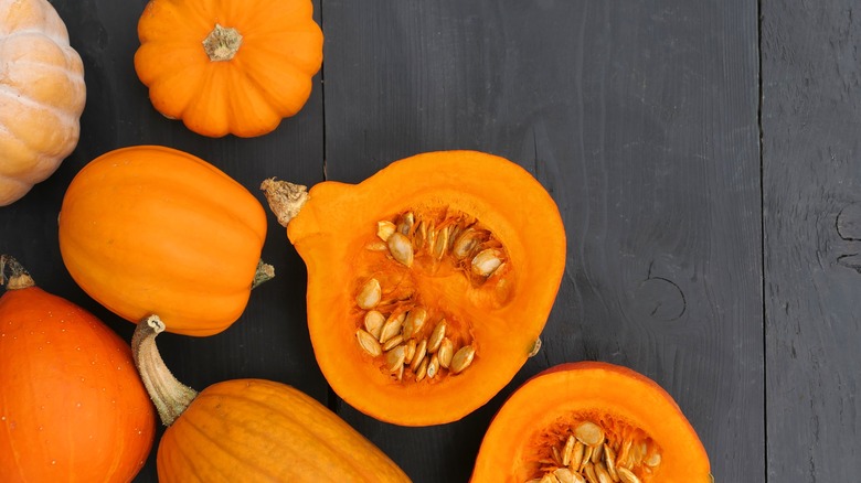 Pumpkins and cut open pumpkins on a table top