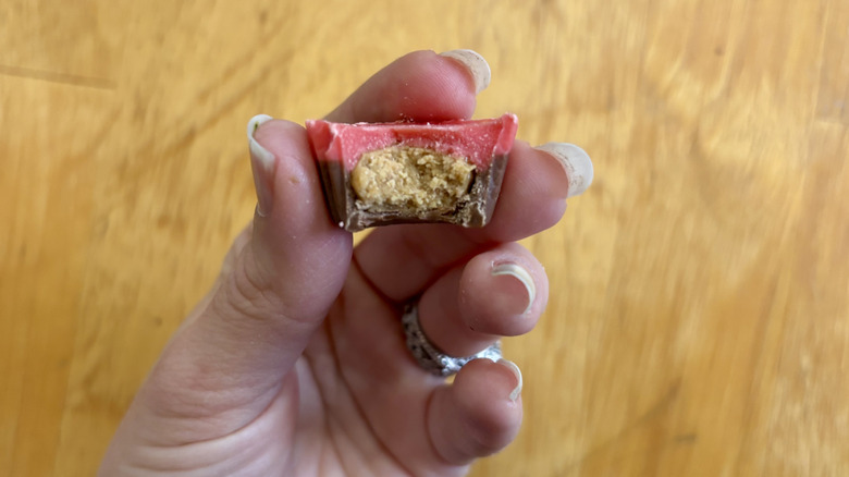 A handheld Reese's cup with a bite taken out of it