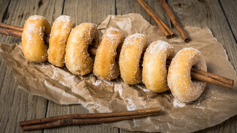 Sugared donuts on a cinnamon stick