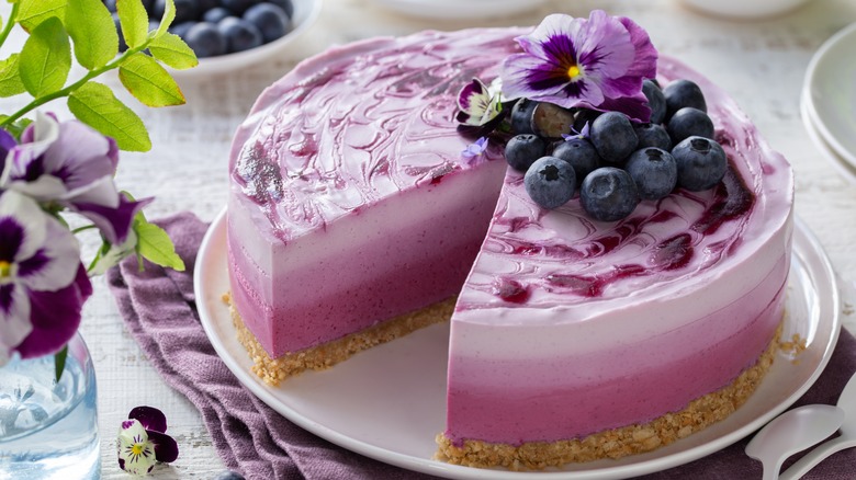 Blueberry cheesecake with edible flower garnish