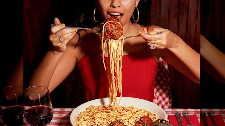 Person eating spaghetti and meatballs