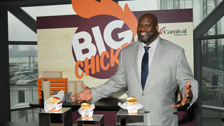 Shaq stands with chicken sandwiches