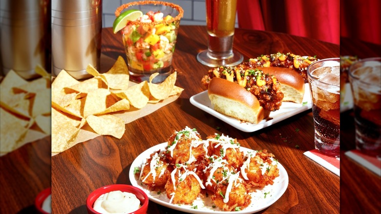 Seafood cocktail, and fried appetizers on a table with beer and shaker