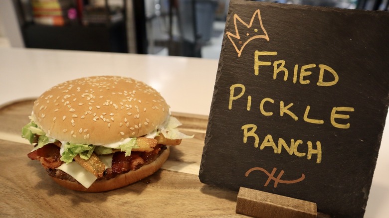 Whopper on wooden board next to sign