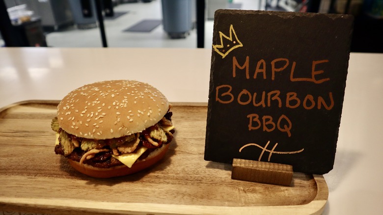 Whopper on wooden board next to sign