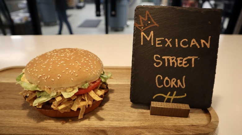 Whopper on wooden board next to sign