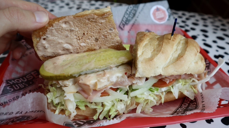 Sub on tray with one half opened up to show pickle