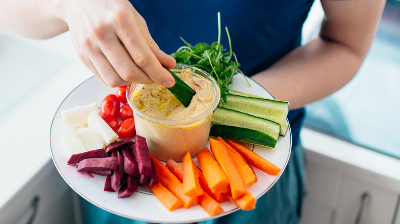 Man eating hummus and vegetables