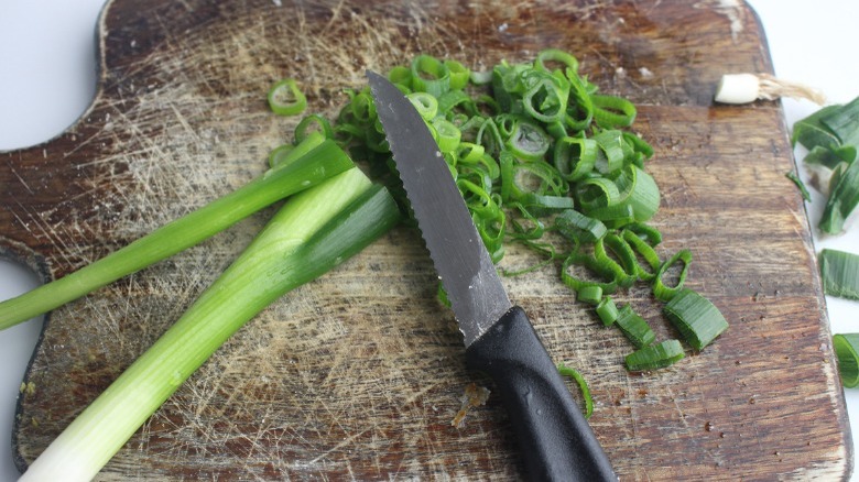 sliced scallions on cutting board