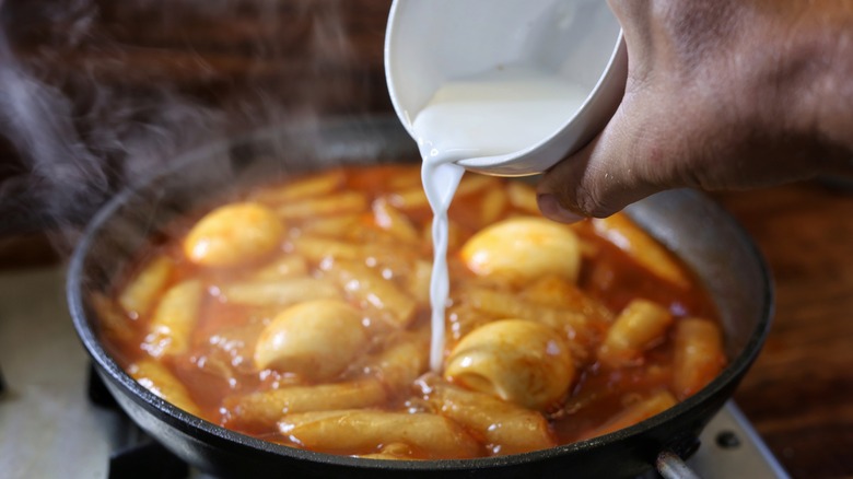 pouring cornstarch slurry into tteokbokki skillet