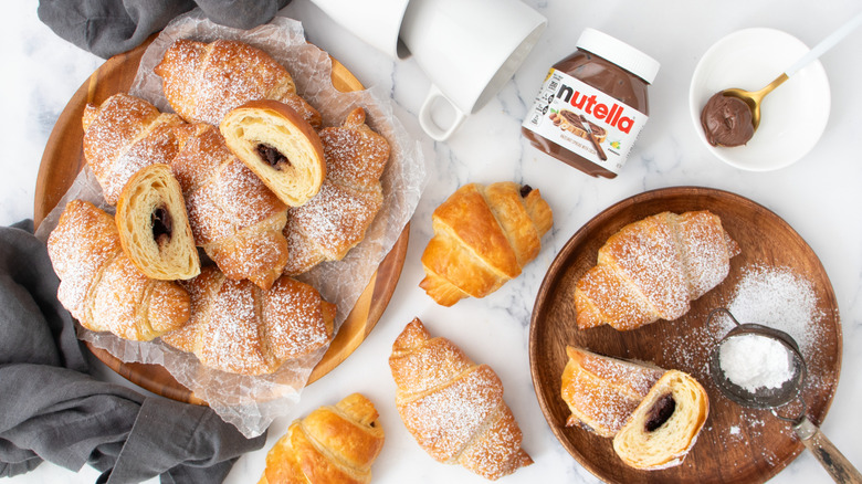 Nutella filled croissants in bowls with nutella jar