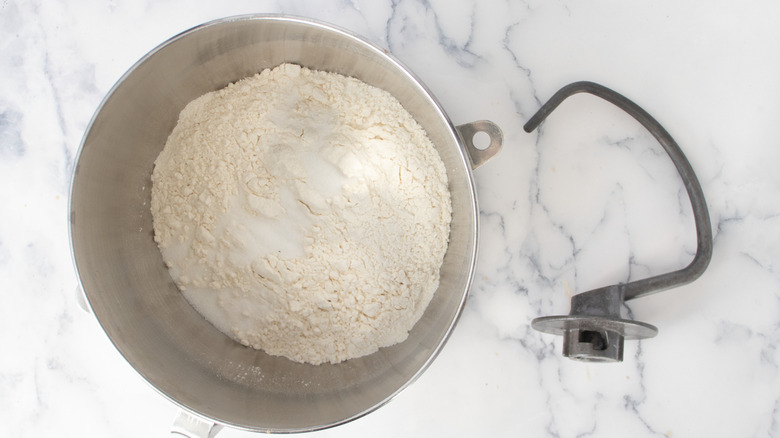 Flour and sugra in stand mixer bowl with hook