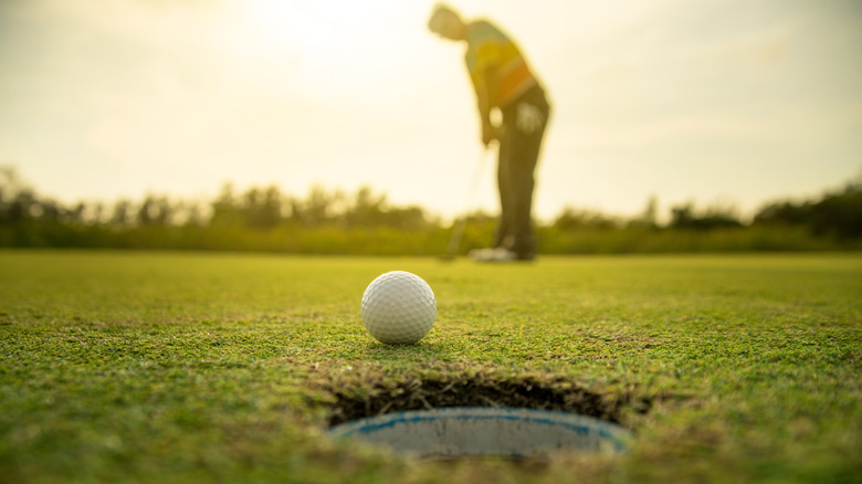 golf ball nearing hole-in-one