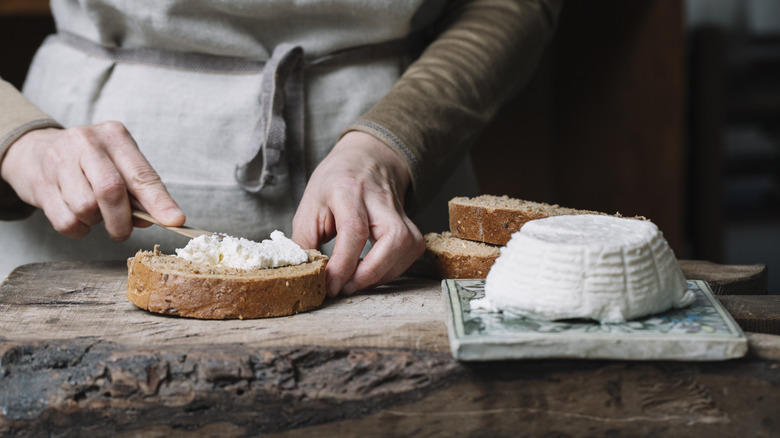 spreading homemade ricotta on bread