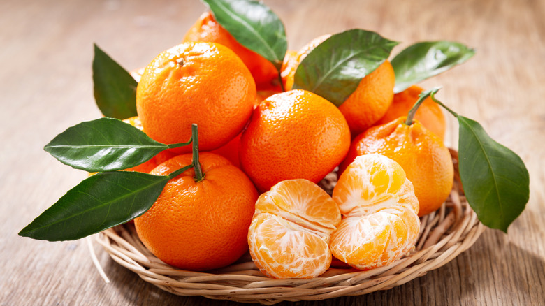 Tangerines in a basket on a wooden table