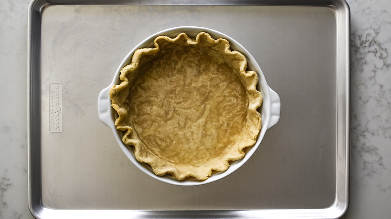 pie crust in pie pan on baking sheet