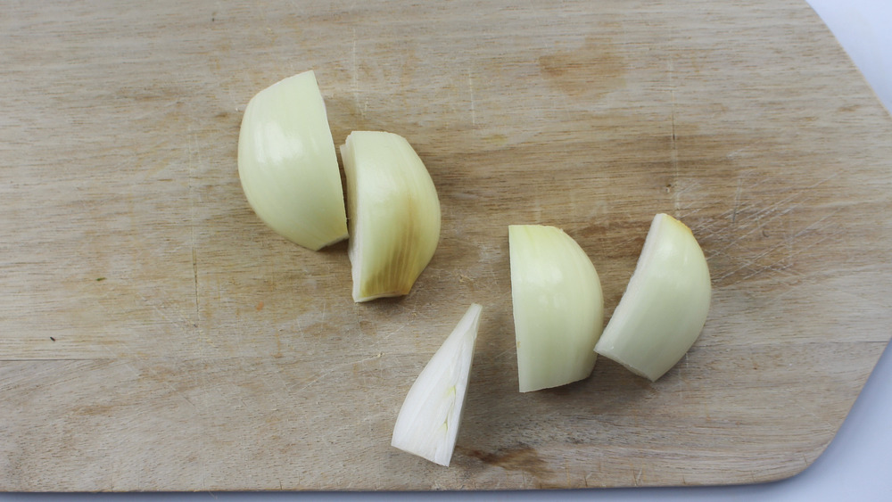 chopped onion on cutting board for roasted carrot soup