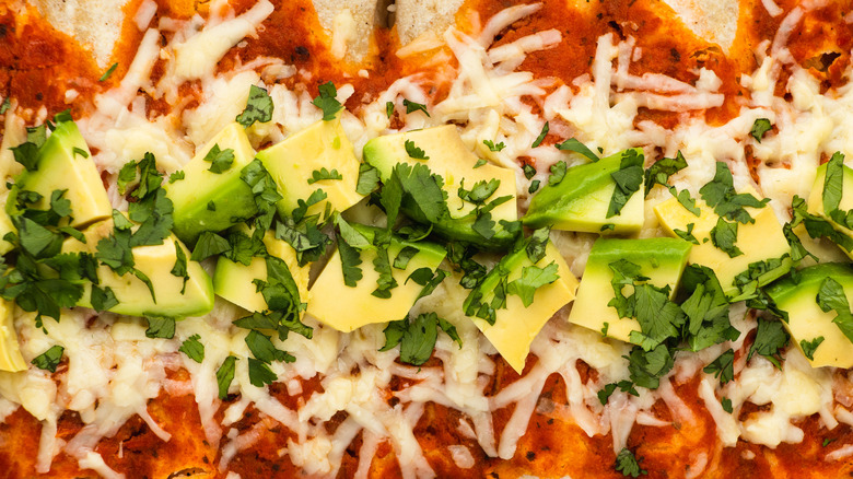 Close up of enchiladas topped with avocado