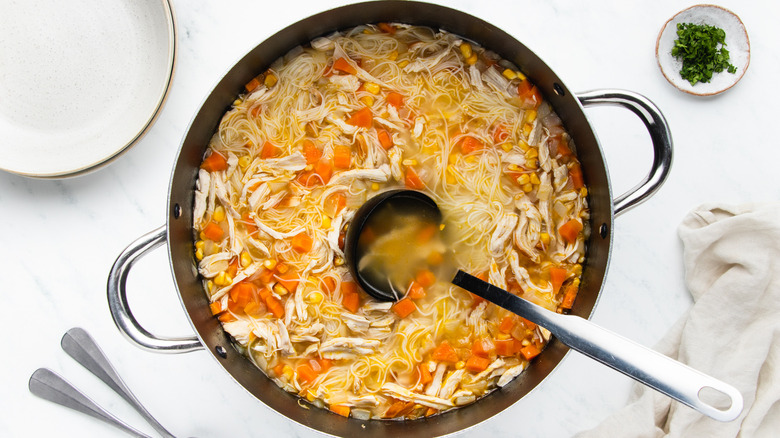 Corn and chicken noodle soup in pot