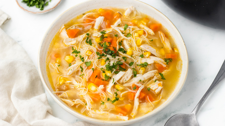 Corn and chicken noodle soup in bowl