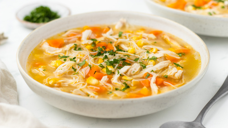 Corn chicken noodle soup in bowl