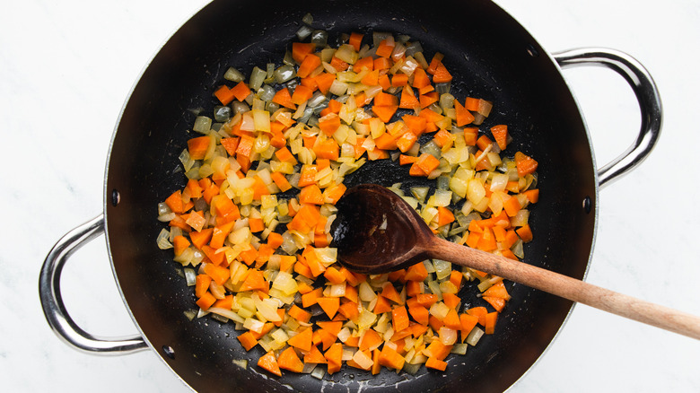 Onion and carrot frying in soup pot