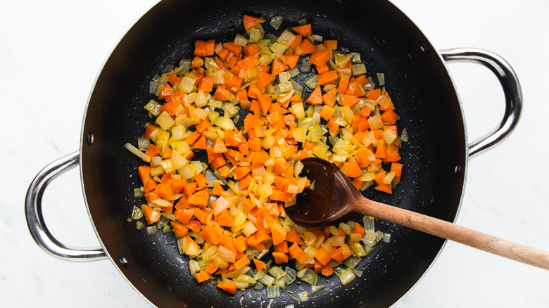 Onion and carrot frying in soup pot