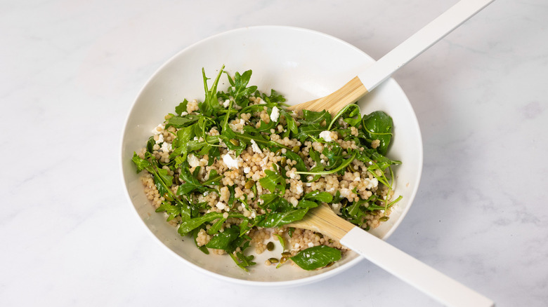 arugula and couscous in bowl