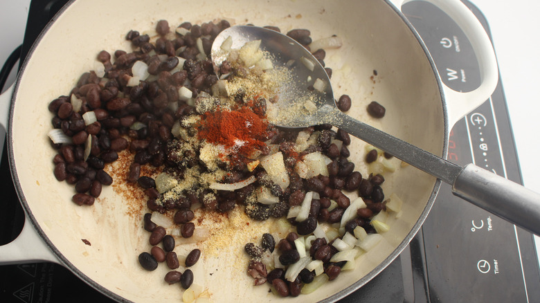 beans, onions, spices in pan