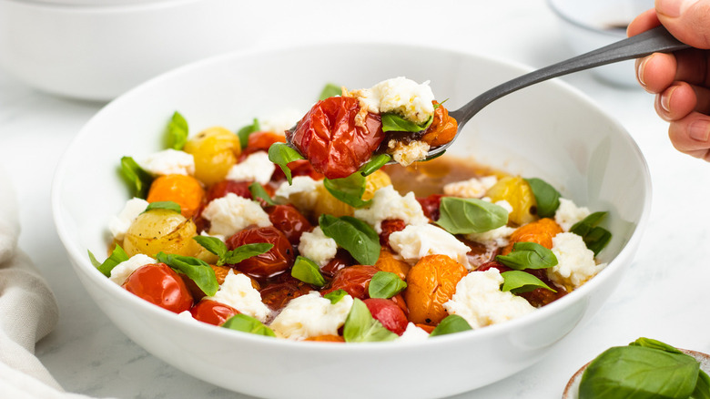 Spooning out tomato Caprese salad