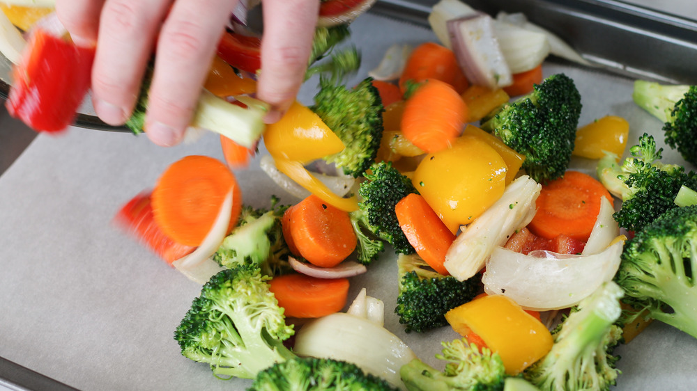 placing roasted vegetables on sheet pan