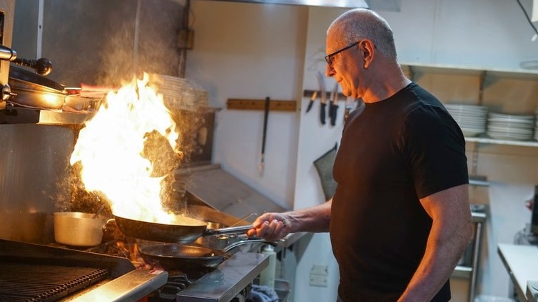 Robert Irvine cooking over stove