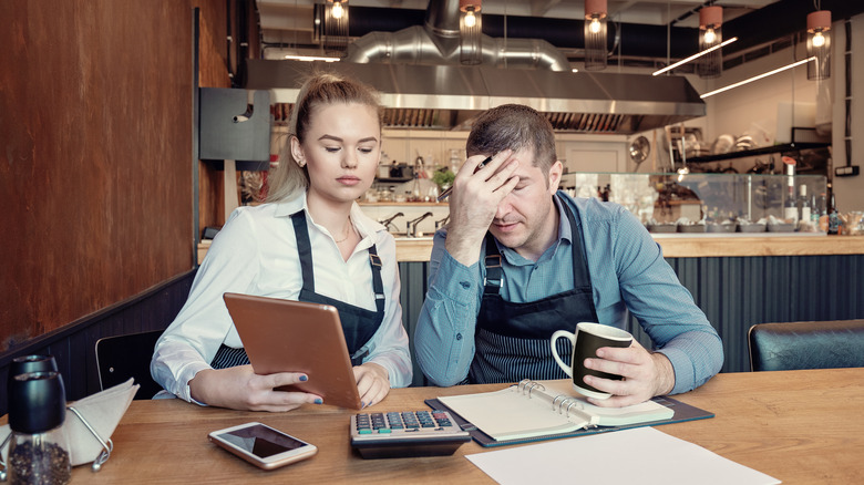 Restaurant owners reviewing books