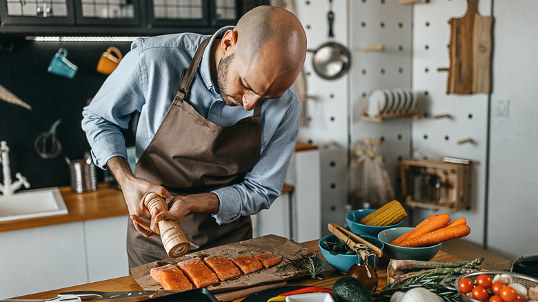 Person preparing fish for grilling