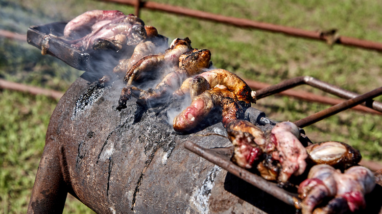 Rocky Mountain oysters cooking on a charcoal burner outdoors on a farm during the seasonal castration of young calves