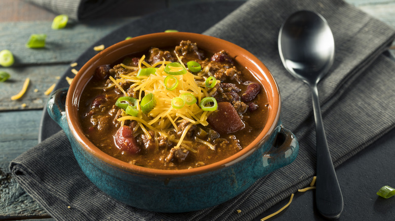 Bowl of chili topped with green onion and cheese