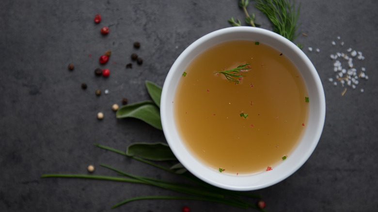 chicken broth in bowl with herbs