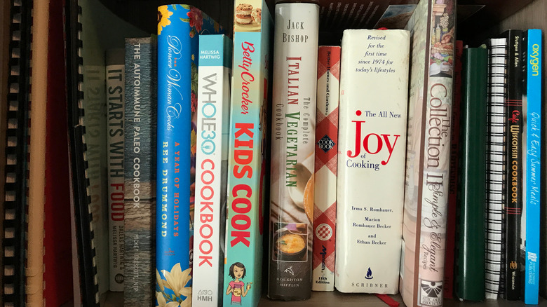 cookbooks crammed together on a shelf