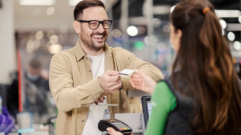 Man laughing at grocery store checkout