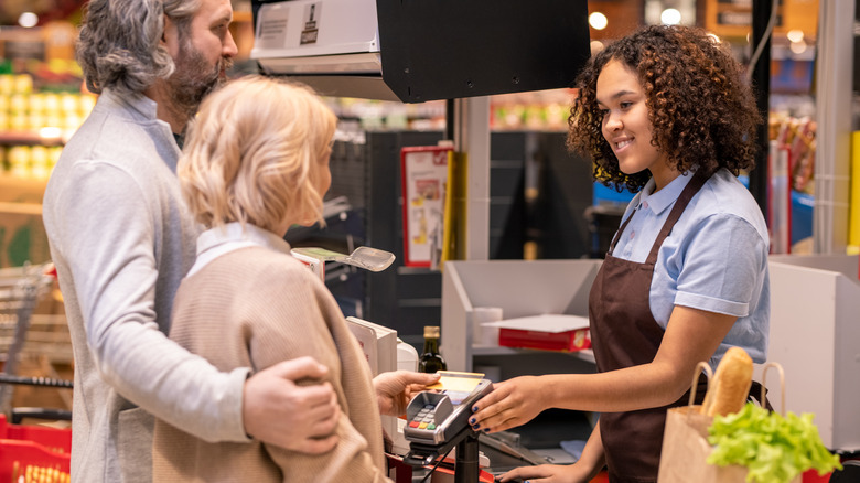 Customers at grocery store checkout