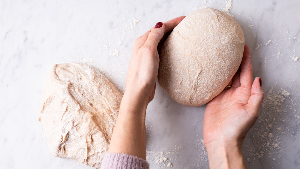 Woman's hands shaping bread dough