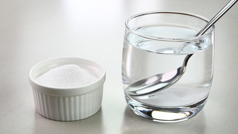 Salt next to a cup of water