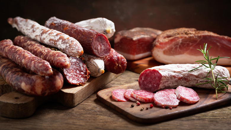 Various types of Italian salami sausages and cuts on wooden cutting boards.