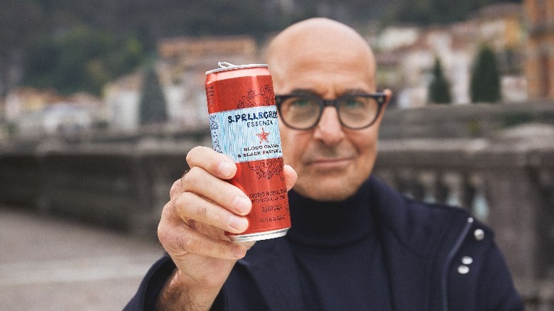 Stanley Tucci holding a can of San Pelligrino